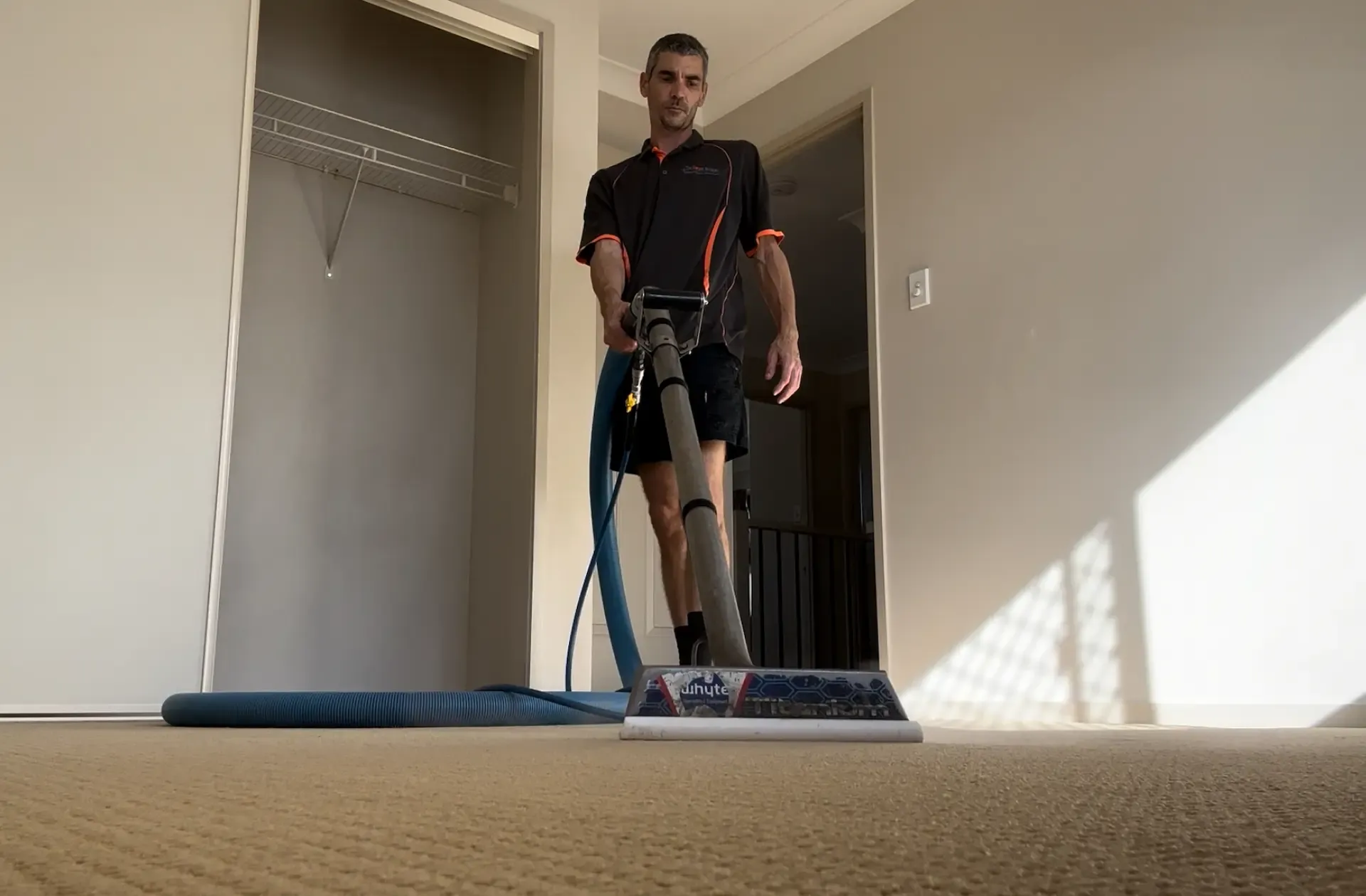 The Carpet Surgeon using a commercial hot water extraction carpet cleaning wand during a professional steam carpet cleaning service.